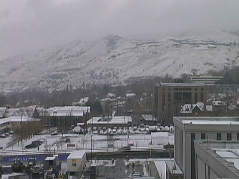 城市冬季场景;白雪覆盖的建筑物，前面的山的街道视频素材