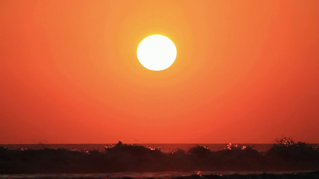 MS太阳落在巨浪冲击海滩的剪影后面/ Legian，巴厘岛，印度尼西亚视频素材