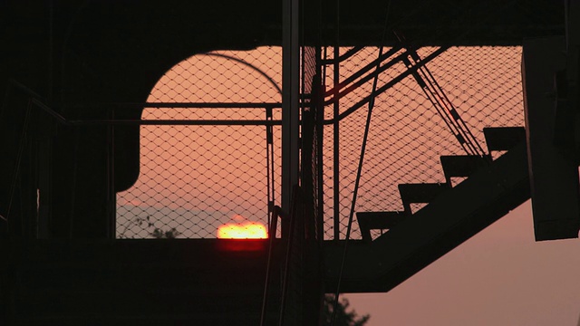 夕阳西下，一名拿着手机的男子走上了通往高架公园的台阶视频素材