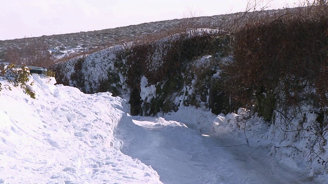 英国达特穆尔，一辆汽车在雪地上行驶视频下载