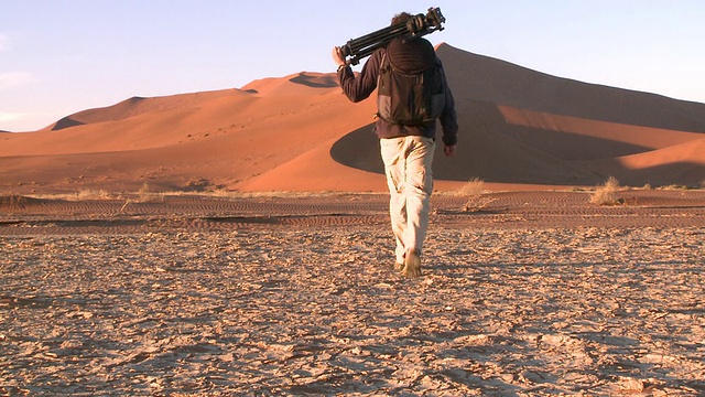 沙丘，一个人拿着三脚架走向沙丘，Sossusvlei，纳米比亚- naukluft视频素材