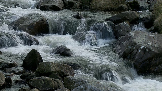 山涧或河流:倾斜的水从岩石和巨石上流过河上的小桥，布雷肯灯塔，威尔士视频素材