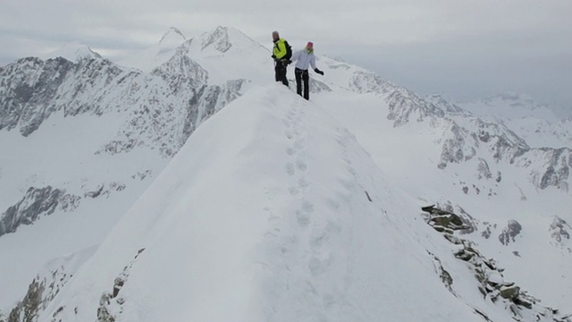 一对登山爱好者在奥地利阿尔卑斯山/斯图拜冰川的白雪覆盖的山上跳舞视频素材