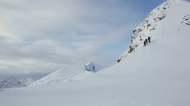 三名登山者在奥地利阿尔卑斯山脉/斯图拜冰川上徒步旅行的雪覆盖的山，泰洛，奥地利视频素材