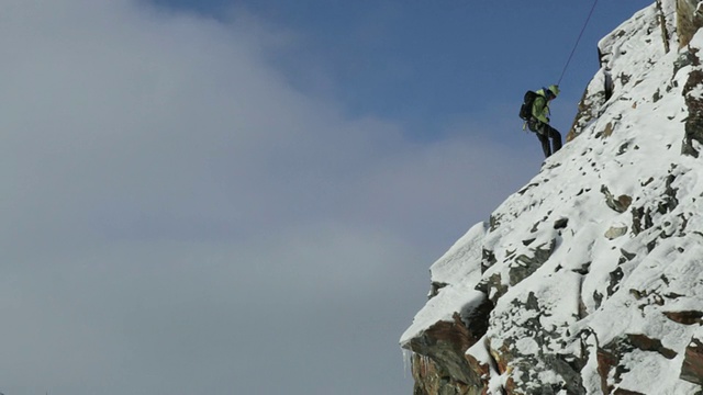 wtu TD登山者在奥地利阿尔卑斯山脉白雪覆盖的山上通过绳索下降/斯图拜冰川，泰洛，奥地利视频素材