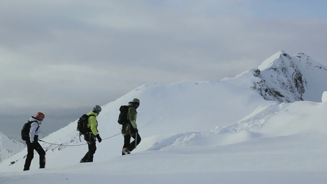 在奥地利阿尔卑斯山脉/斯图拜冰川上徒步旅行的三名登山者视频素材