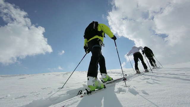 在早晨的阳光下，三名登山者在奥地利阿尔卑斯山的冰雪覆盖的山上徒步旅行/奥地利泰洛的斯图拜冰川视频素材