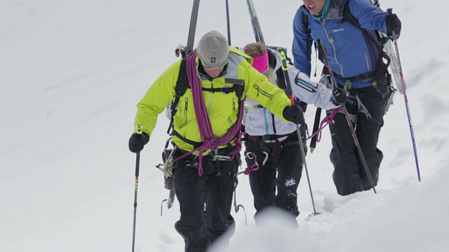 在早晨的阳光下，三名登山者在奥地利阿尔卑斯山的冰雪覆盖的山上徒步旅行/奥地利泰洛的斯图拜冰川视频素材