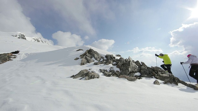 一对夫妇在奥地利阿尔卑斯山/斯图拜冰川的冰雪覆盖的山上登山视频素材