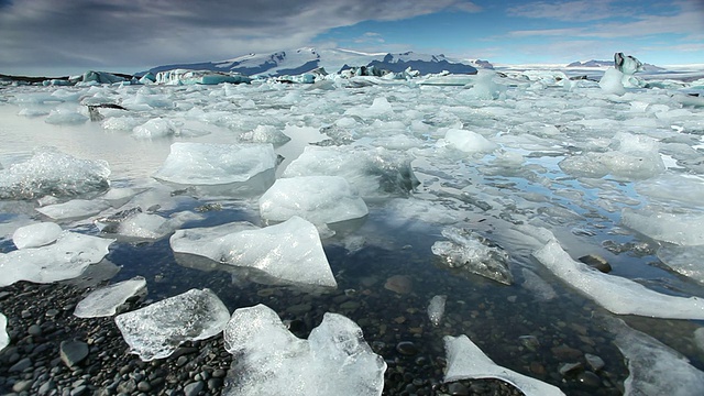 巨大的冰块和冰山漂浮在冰雪覆盖的山脉前，在Jokulsarlon冰川湖/斯卡夫塔菲尔国家公园和霍夫之间，奥斯特-斯卡夫塔费尔西拉，冰岛视频素材