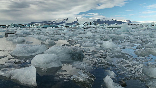 巨大的冰块和冰山漂浮在冰雪覆盖的山脉前，在Jokulsarlon冰川湖/斯卡夫塔菲尔国家公园和霍夫之间，奥斯特-斯卡夫塔费尔西拉，冰岛视频素材