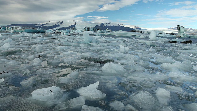 巨大的冰块和冰山漂浮在冰雪覆盖的山脉前，在Jokulsarlon冰川湖/斯卡夫塔菲尔国家公园和霍夫之间，奥斯特-斯卡夫塔费尔西拉，冰岛视频素材