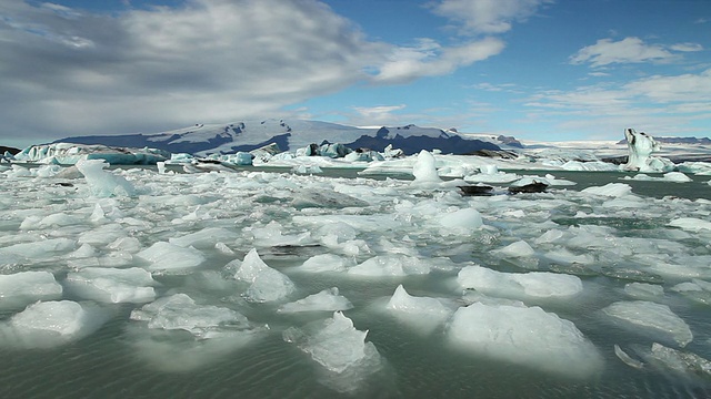 巨大的冰块和冰山漂浮在冰雪覆盖的山脉前，在Jokulsarlon冰川湖/斯卡夫塔菲尔国家公园和霍夫之间，奥斯特-斯卡夫塔费尔西拉，冰岛视频素材