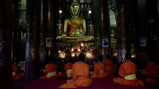 老挝琅勃拉邦，琅勃拉邦，琅勃拉邦，佛教寺庙里的僧侣晚上祈祷视频素材