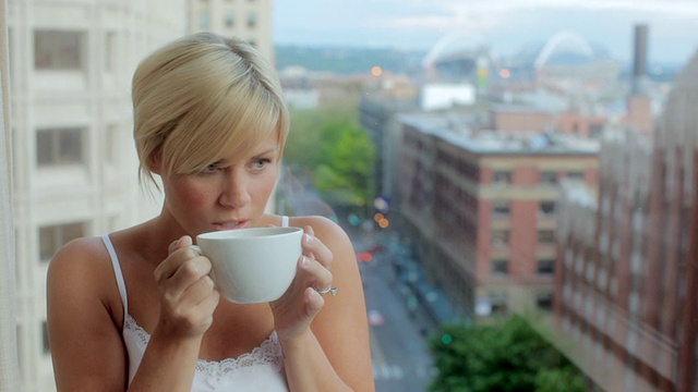 MS Woman looking out the hotel window with coffee mug /西雅图，WA，美国视频素材