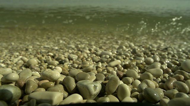 SLO MO海浪在卵石海滩冲向相机，西班牙视频素材