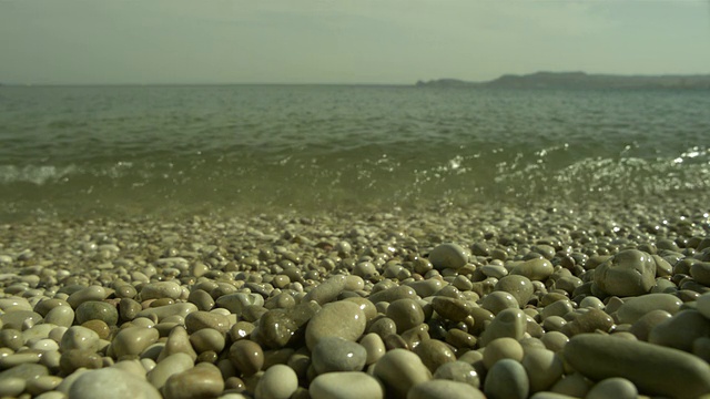 SLO MO海浪在卵石海滩冲向相机，西班牙视频素材