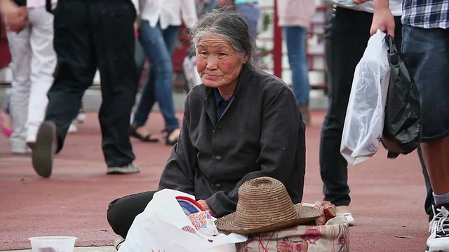 无家可归的女人坐在人行道上/陕西西安，中国视频素材