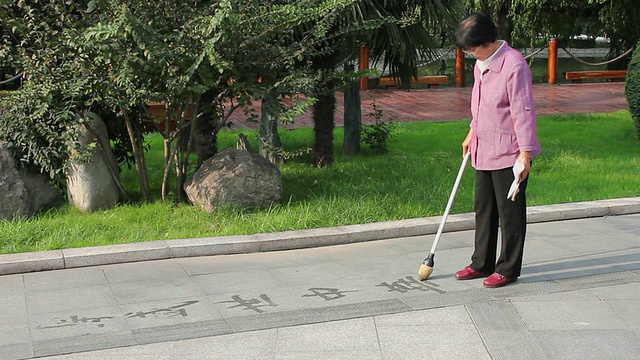 中国陕西西安的公园里，人们在人行道上写书法视频素材