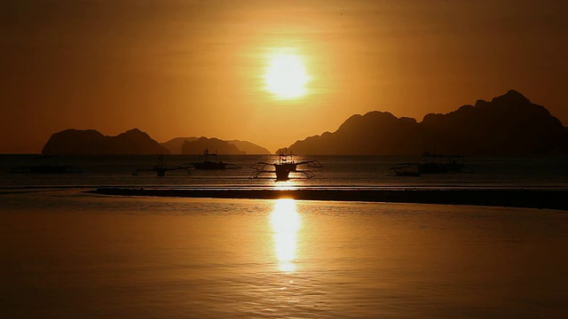 “WS，落日下漂浮的支腿船的轮廓，背景是巴库特群岛/ Corong Corong湾，El Nido，巴拉望，菲律宾”视频素材