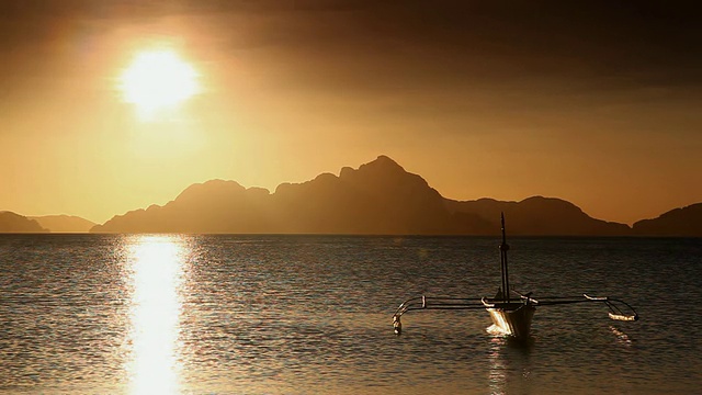 “LS，在夕阳下漂浮的支腿船的轮廓，背景是巴库特群岛/ Corong Corong湾，El Nido，巴拉望，菲律宾”视频素材