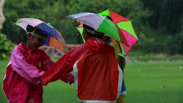 三个孩子在雨中玩耍视频素材