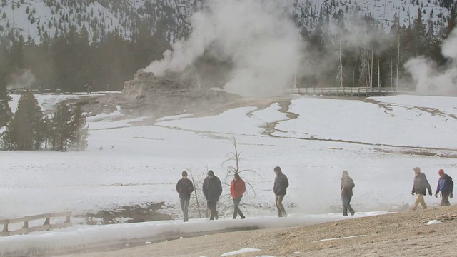 美国怀俄明州，黄石国家公园，游客走过雪中间歇泉视频素材