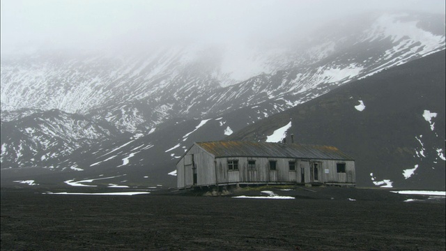 WS，废弃的科学站，雪山覆盖着雾的背景，欺骗岛，南极洲视频素材