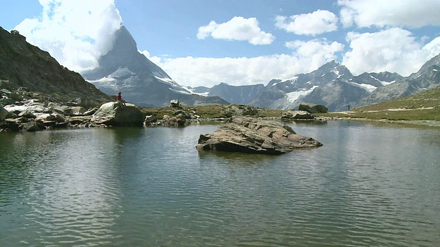 在瑞士瓦莱的riffelsee和matterhorn / Zermatt，女性徒步旅行者坐在岩石上视频素材