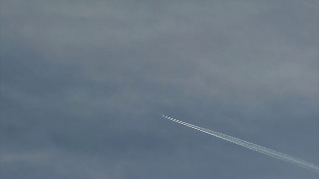 远处飞机飞过天空，留下长长的蒸汽尾迹。摄于英国视频素材