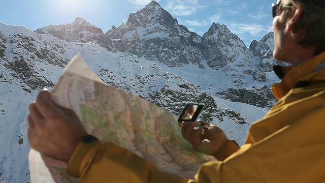 一名男性登山运动员正在看地图和指南针视频素材