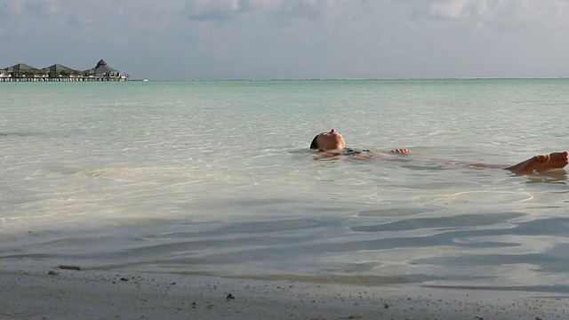 少女漂浮在平静的泻湖水面上视频素材