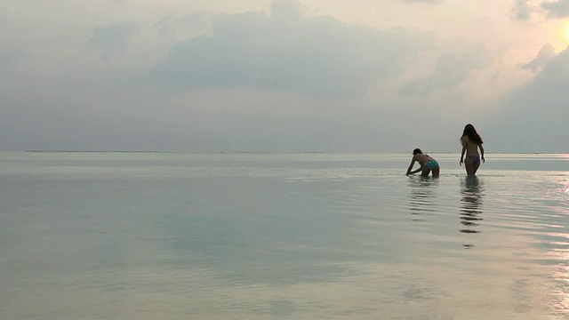 十几岁的女孩走过浅浅的泻湖水，然后跳进水里视频素材