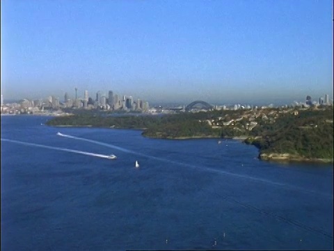 西澳大利亚航空飞越悉尼港，远处海港大桥和高楼大厦视频素材