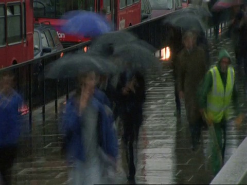 T/L MS高角度的人走在雨中繁忙的城市街道上，车流在背景中，伦敦桥视频素材