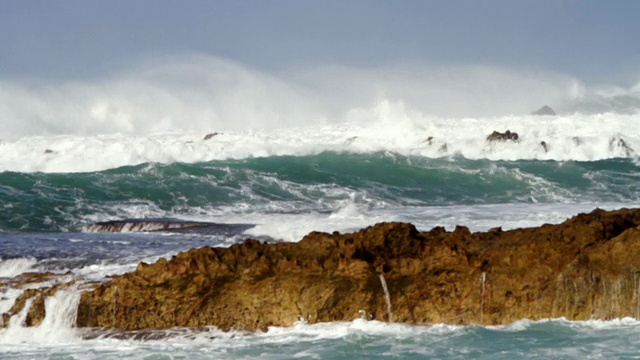 海浪冲击着岸边的熔岩岩石/ Haleiwa，夏威夷，美国视频素材