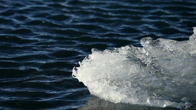 融化的冰川漂浮和移动在jokulsarlon湖上的风在湖/冰岛产生涟漪视频素材