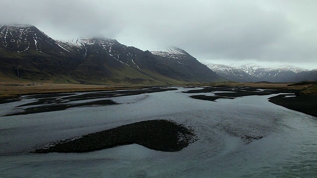 解冻的水流向河流和雪山后面/冰岛视频素材