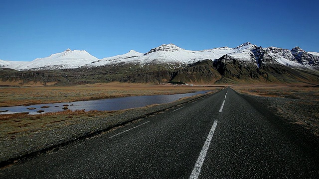 雪覆盖的山/冰岛前的道路WS视图视频素材