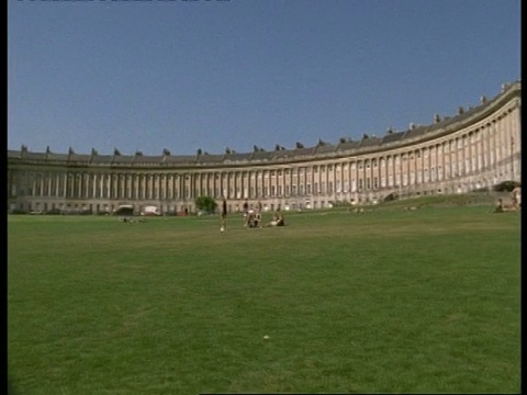 Royal Crescent, Bath, Avon - WA pan横跨长新月形建筑，人们散布在草地前景视频素材