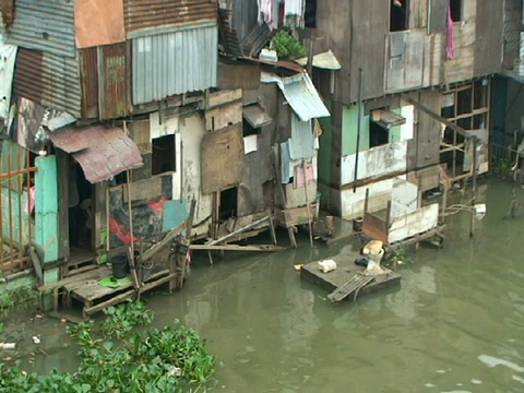 2009年，菲律宾马尼拉，台风美利纳，膨胀的帕西格河岸边的简陋房屋视频素材