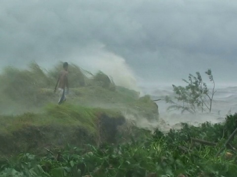 2009年，菲律宾，台风美利奈，男人走在被风暴海浪和浪花袭击的湖边视频素材