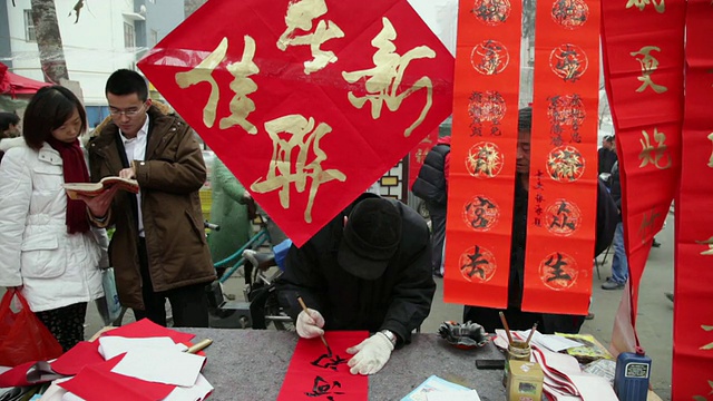 中国陕西西安，一个中国人在街道市场写春联视频素材