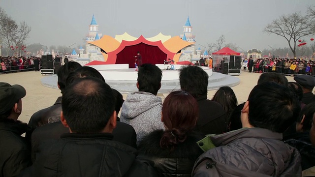 中国陕西西安，庙会上，人们围在一起看木偶戏庆祝春节视频素材