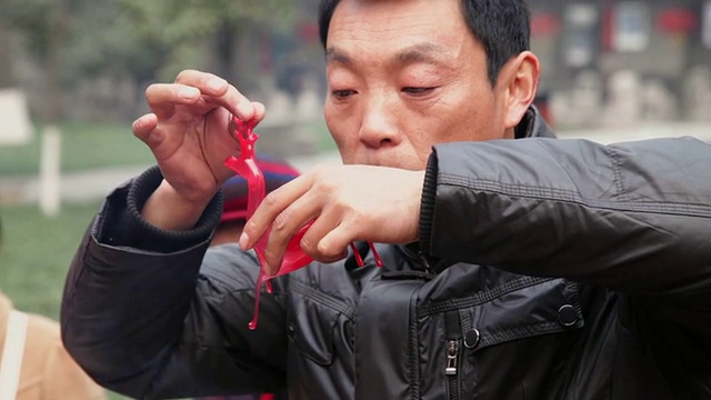 中国陕西西安，古曼制作的糖人偶在庙会上出售庆祝春节视频素材