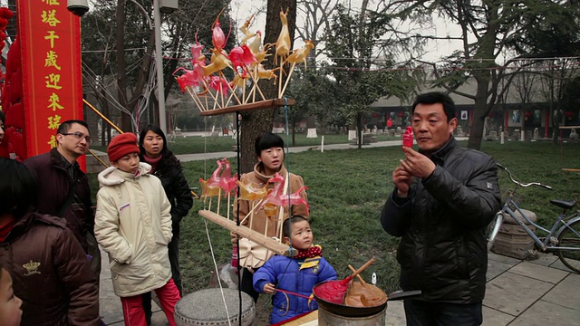 中国陕西西安，曼女士在庙会上制作糖人偶，庆祝春节视频素材