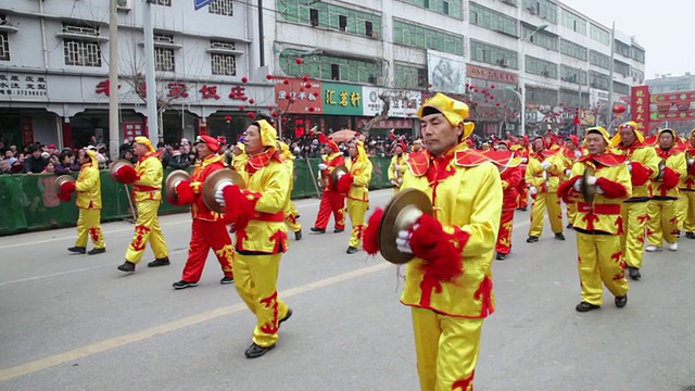 潘小姐在中国传统节日的民间庆典或狂欢节上表演锣鼓视频素材