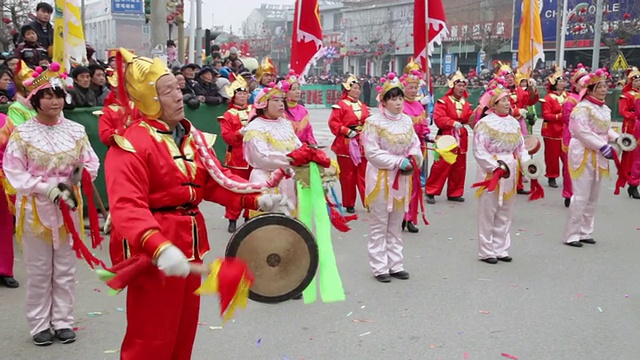 潘小姐:中国春节期间，村民们在传统节日的民间庆典或狂欢节上表演锣鼓视频素材