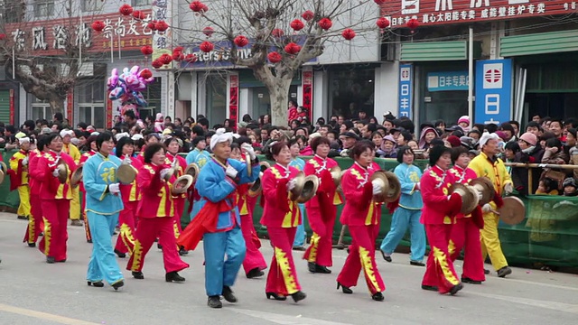 潘小姐在中国传统节日的民间庆典或狂欢节上表演锣鼓视频素材