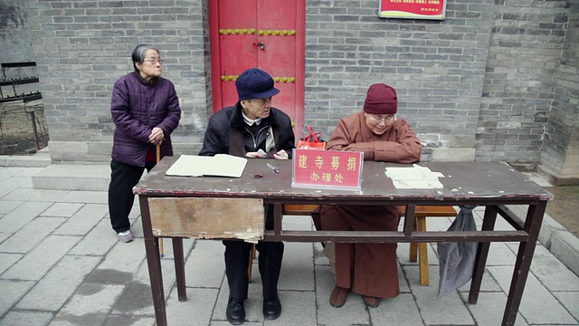 在中国农历新年期间，中国陕西西安，MS寺工作人员在佛寺接受捐款视频素材